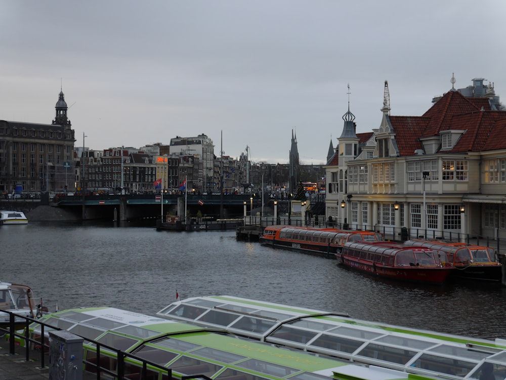 a river filled with lots of boats next to tall buildings