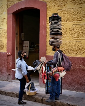 a man with a large stack of hats on his head