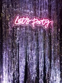 A vibrant neon sign illuminating a festive event space.