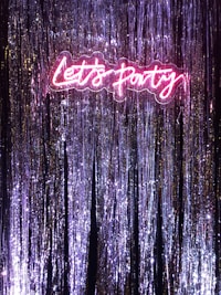 A vibrant neon sign illuminating a festive event space.