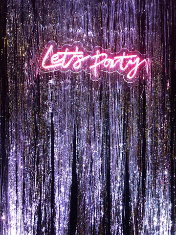 a neon sign that says let's party on it