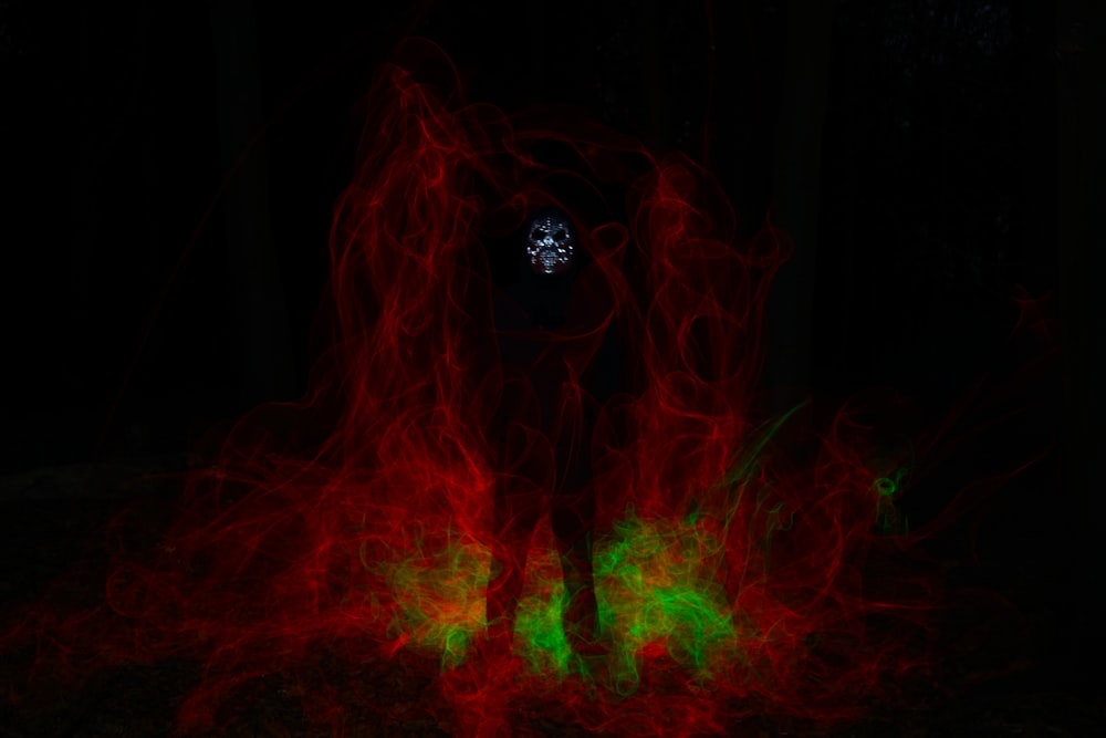 a person standing in the dark with red and green lights