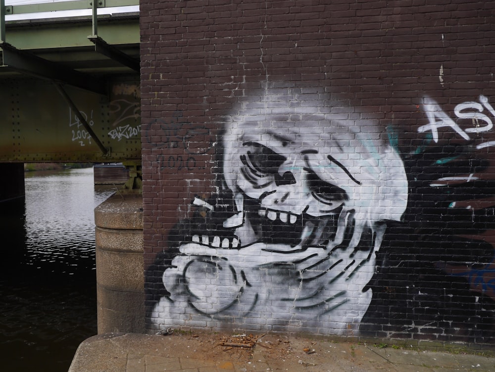 uma parede de tijolos com uma pintura de um esqueleto fumando um cigarro