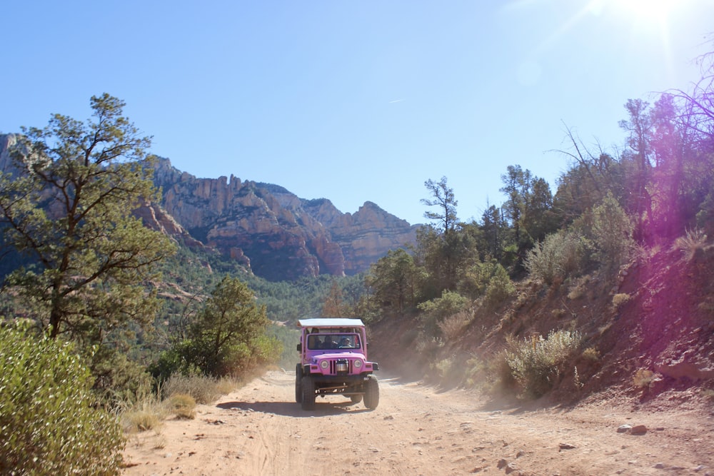 Une jeep descendant un chemin de terre dans les montagnes