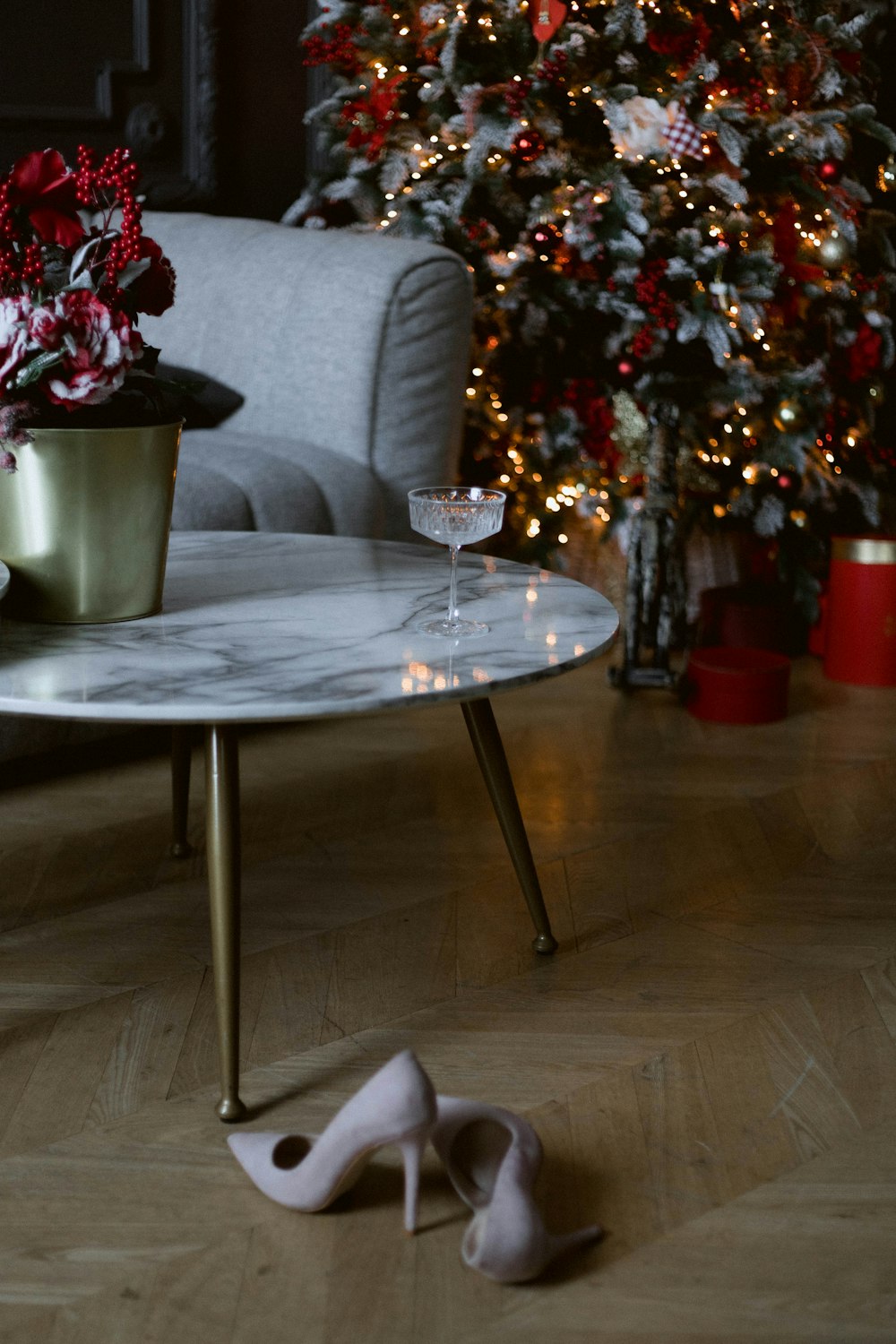 크리스마스 트리 옆 테이블 위에 앉아 있는 흰색 신발 한 켤레