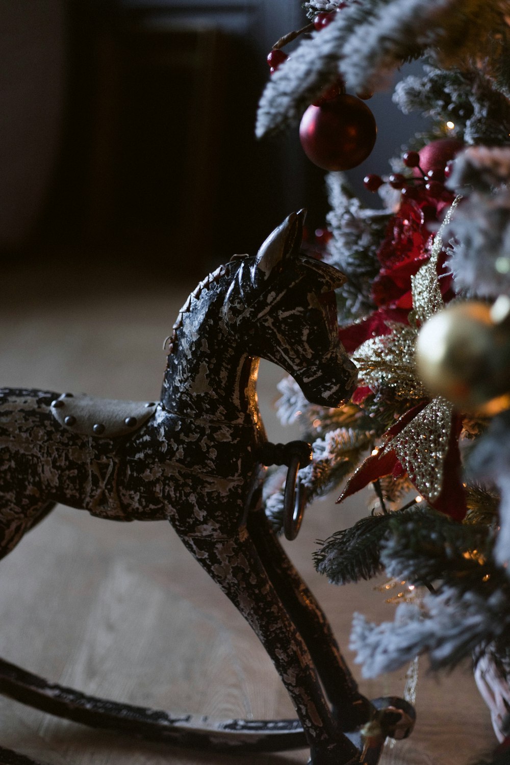 Un caballo balancín junto a un árbol de Navidad
