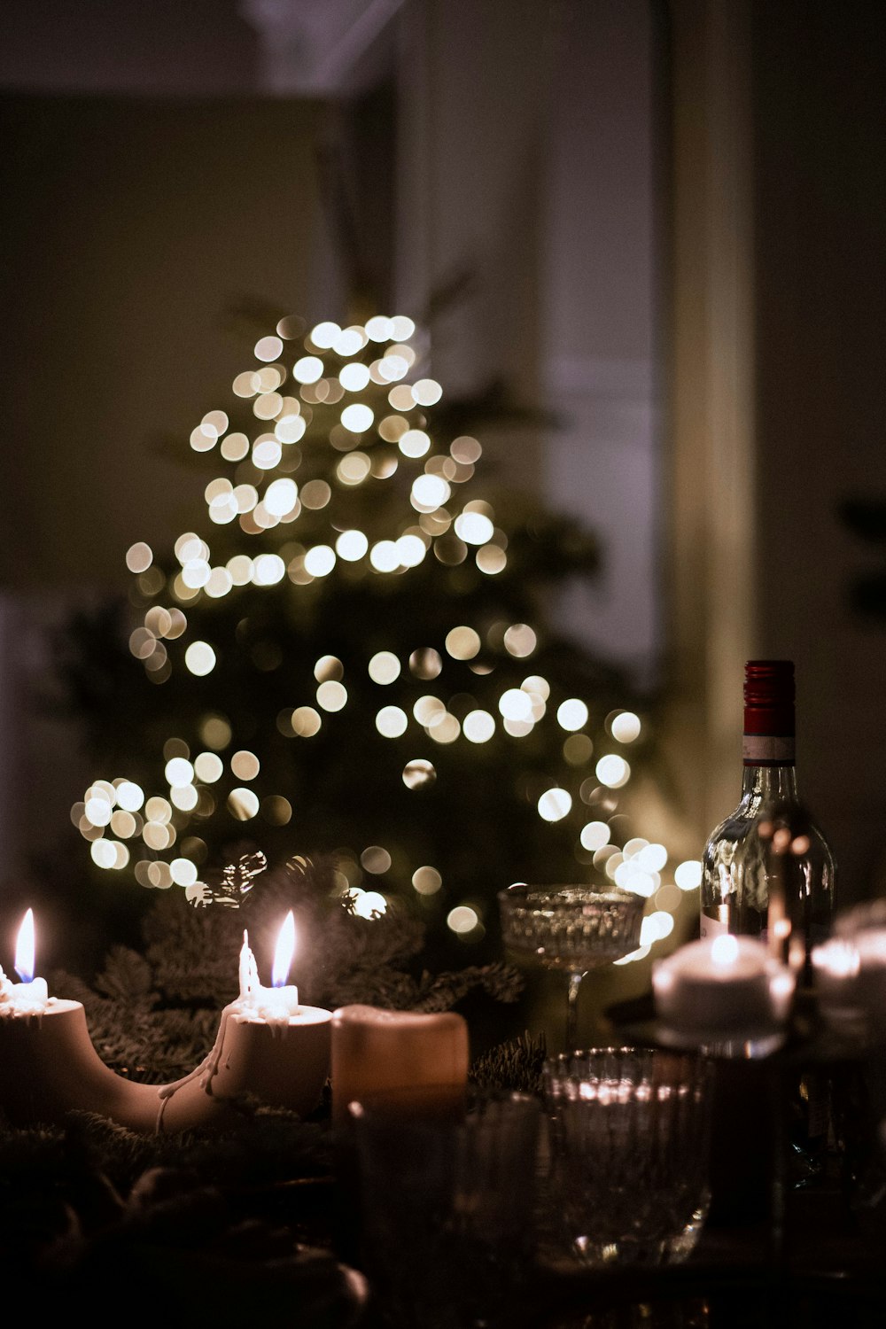 una mesa cubierta con velas y una botella de vino