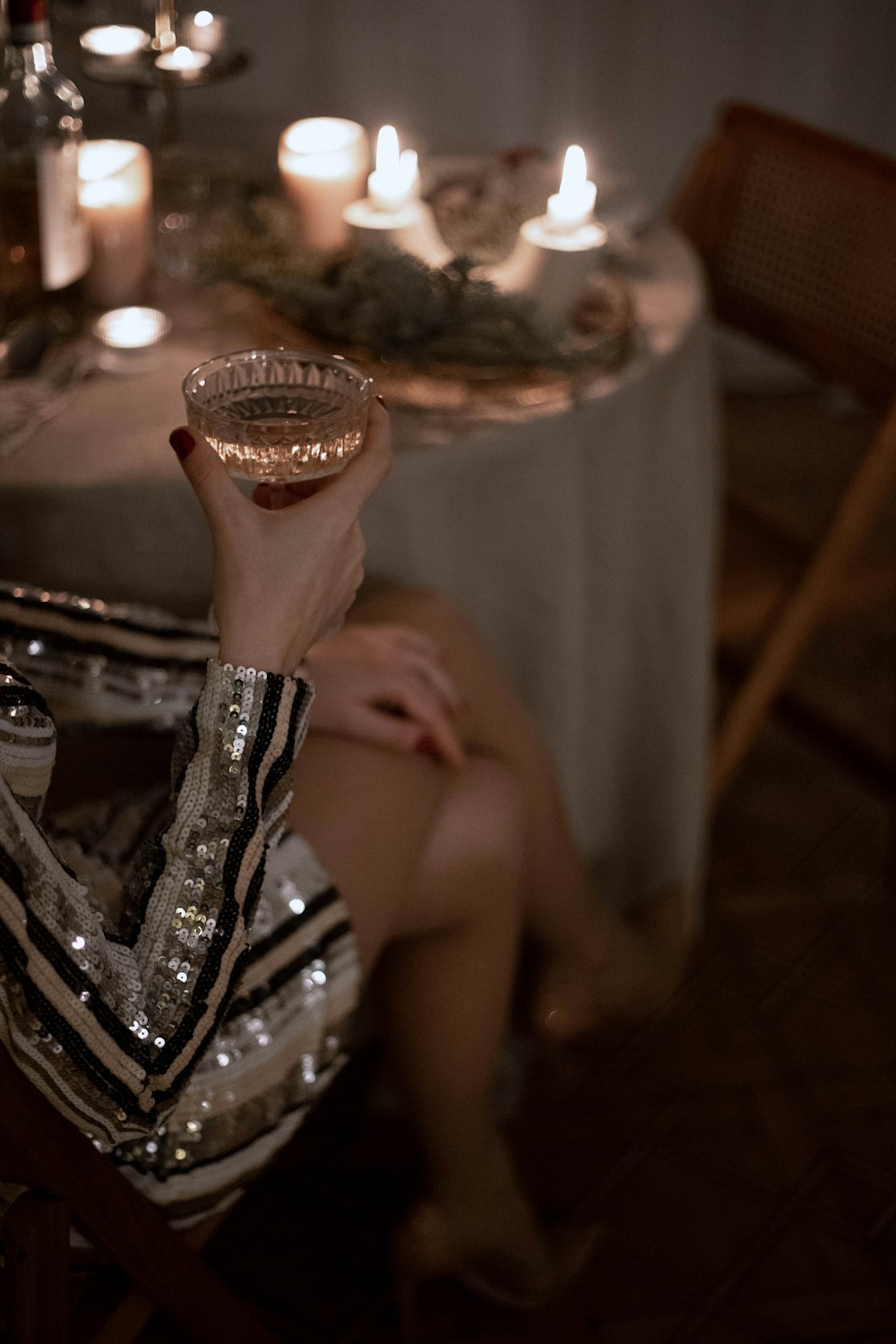 a woman sitting at a table holding a wine glass