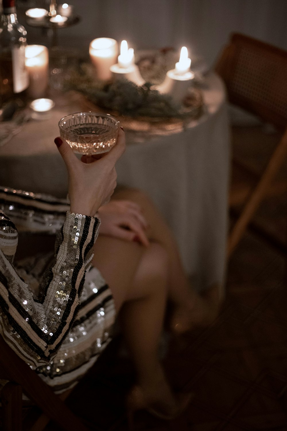 una donna seduta a un tavolo che tiene un bicchiere di vino