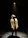 A young girl smiling brightly on stage under warm spotlight during a theater rehearsal.