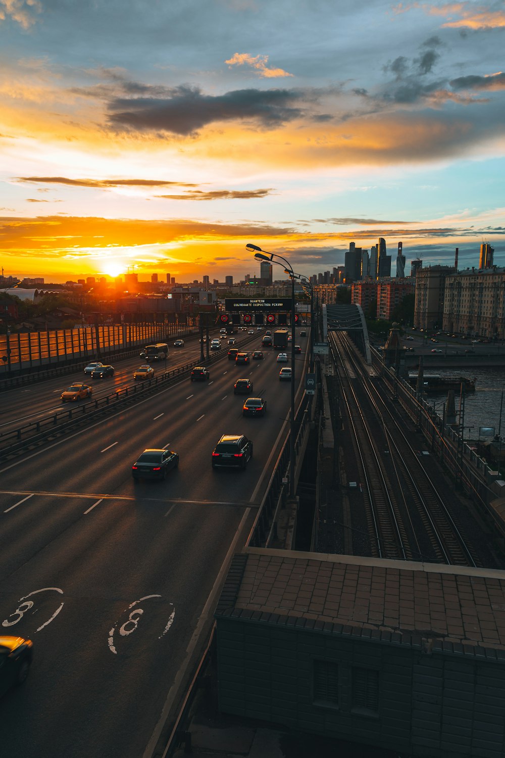a sunset view of a highway with cars driving on it