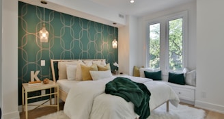 a bedroom with a green wall and a white bed