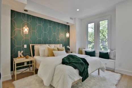 a bedroom with a green wall and a white bed