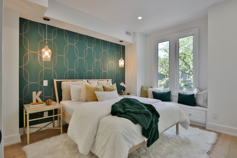 a bedroom with a green wall and a white bed