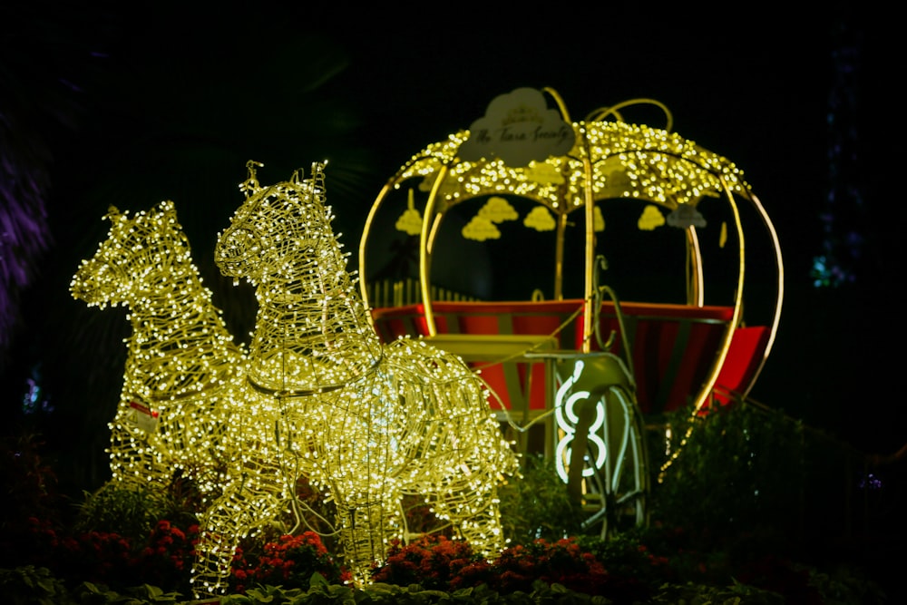 a lighted horse and carriage in a garden