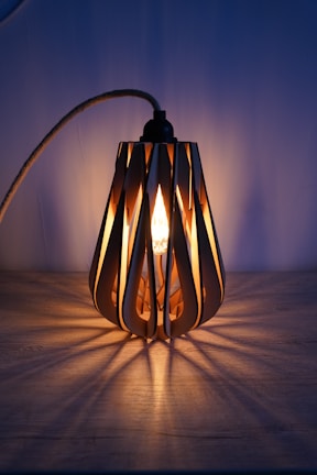 Artisan crafting a wooden lamp with delicate details and warm light.