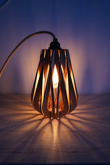 Close-up of a handcrafted wooden lamp with warm glowing light highlighting the natural grain.