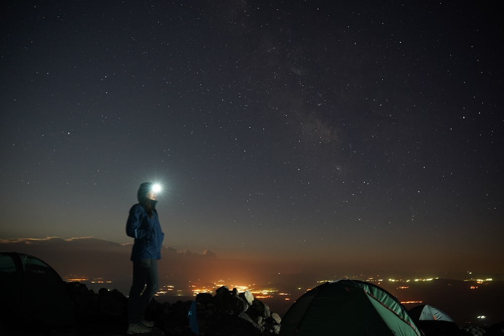 a person standing on top of a hill at night