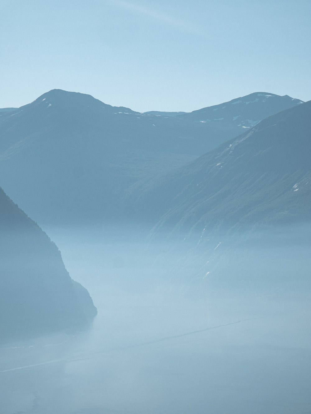 a view of a mountain range in the fog