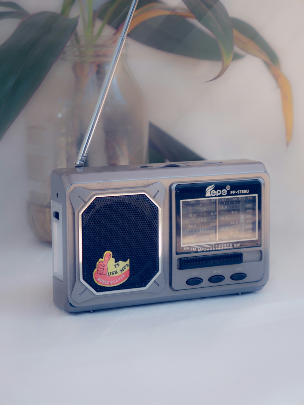 una radio sentada encima de una mesa junto a una planta en maceta