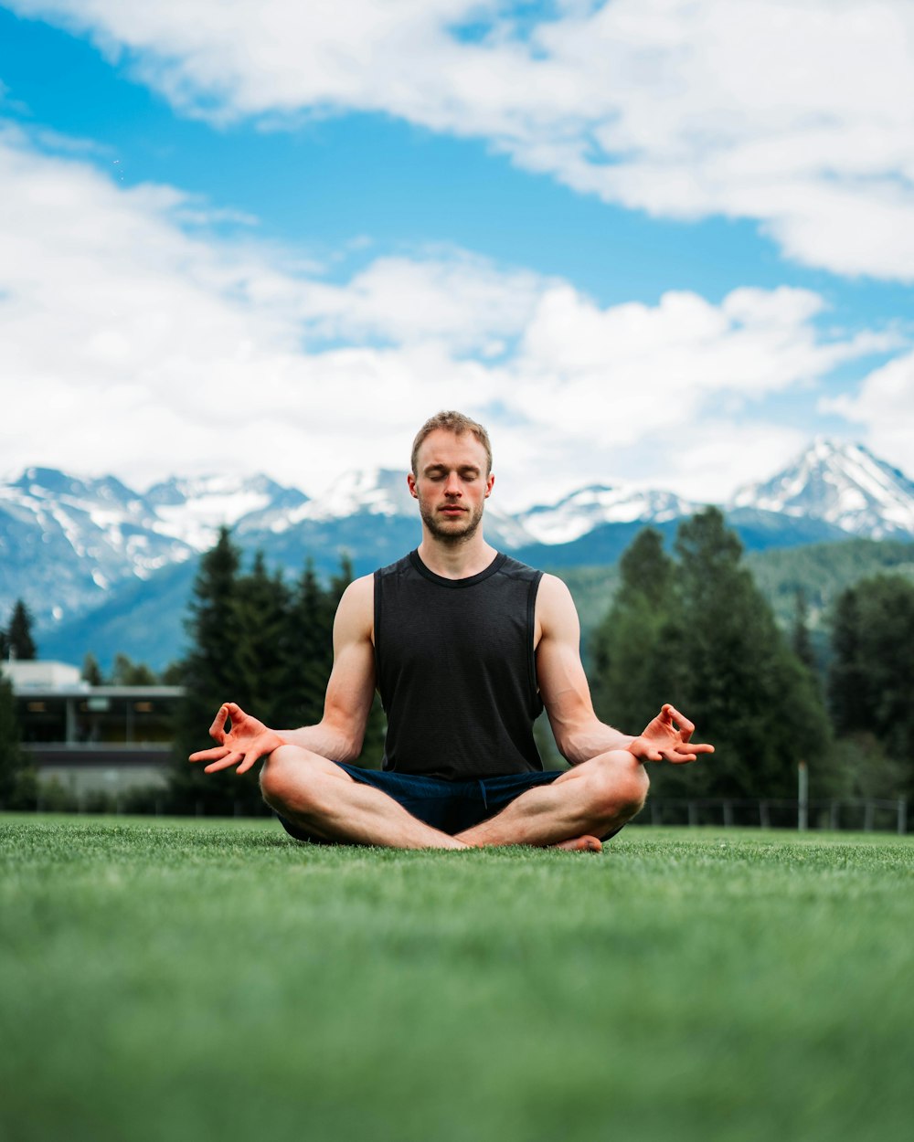 a man sitting in a yoga position in a field