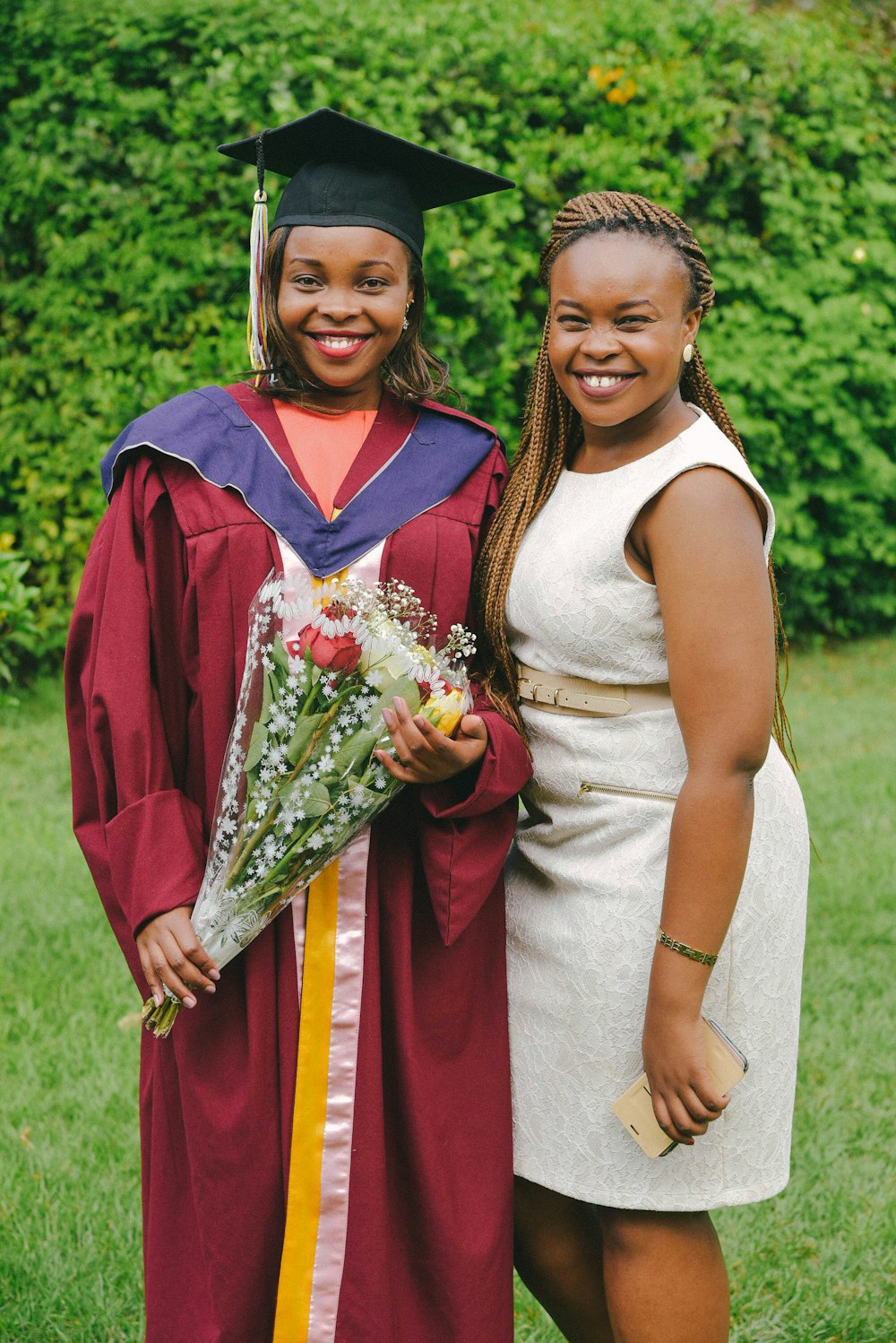 two women in graduation gowns posing for a picture