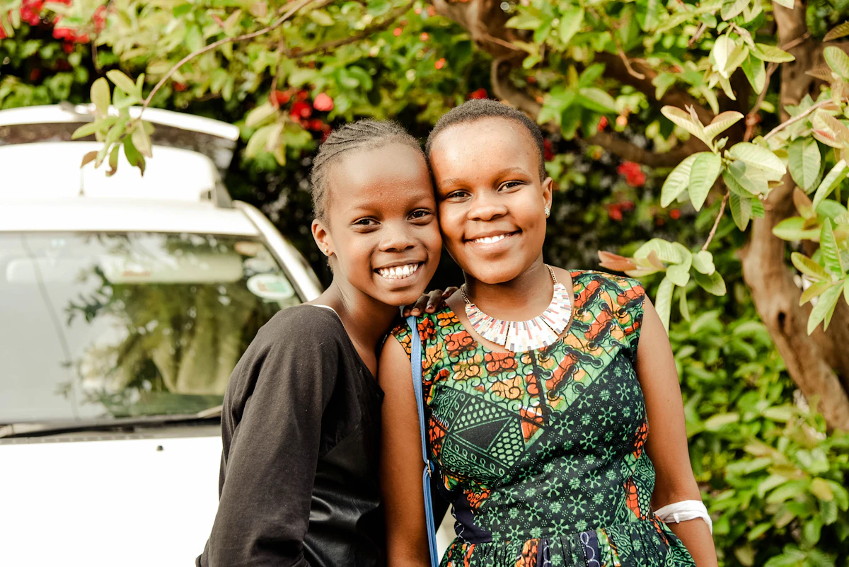 Two young sisters smiling together in Nairobi, Kenya