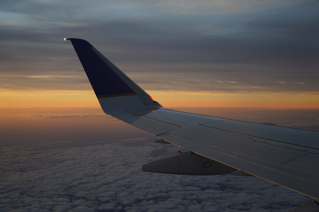 the wing of an airplane as the sun sets, Flying Delta at sunrise