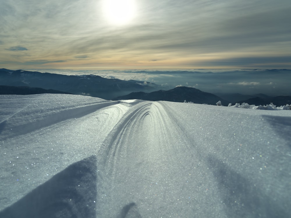 a snow covered road in the middle of a mountain