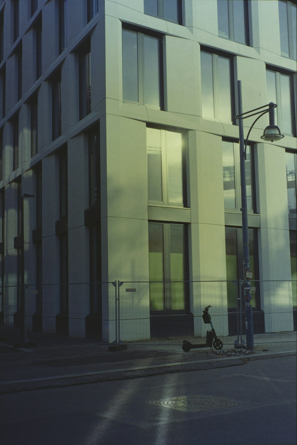 a motorcycle parked on the side of a street next to a tall building