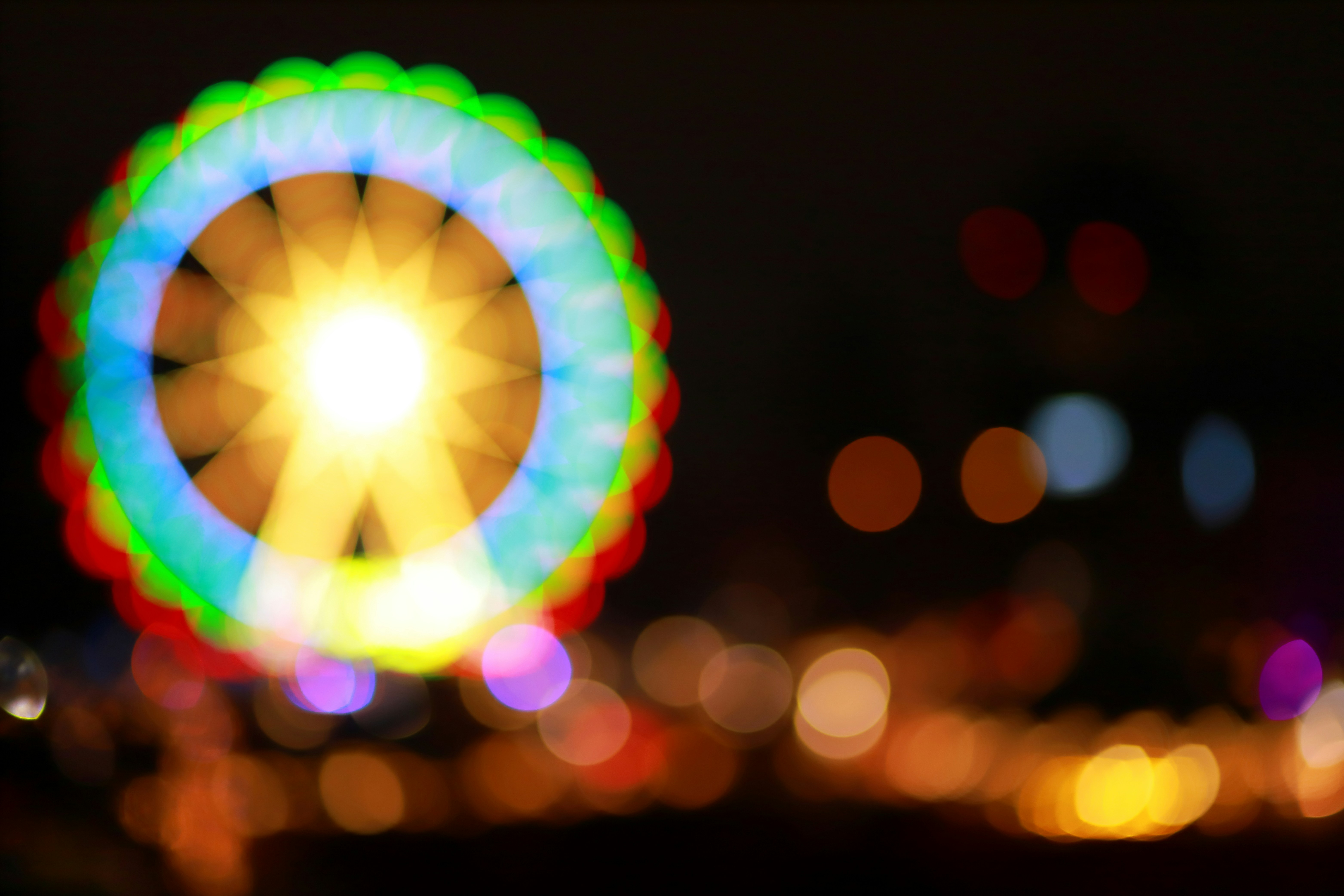 a blurry photo of a ferris wheel at night