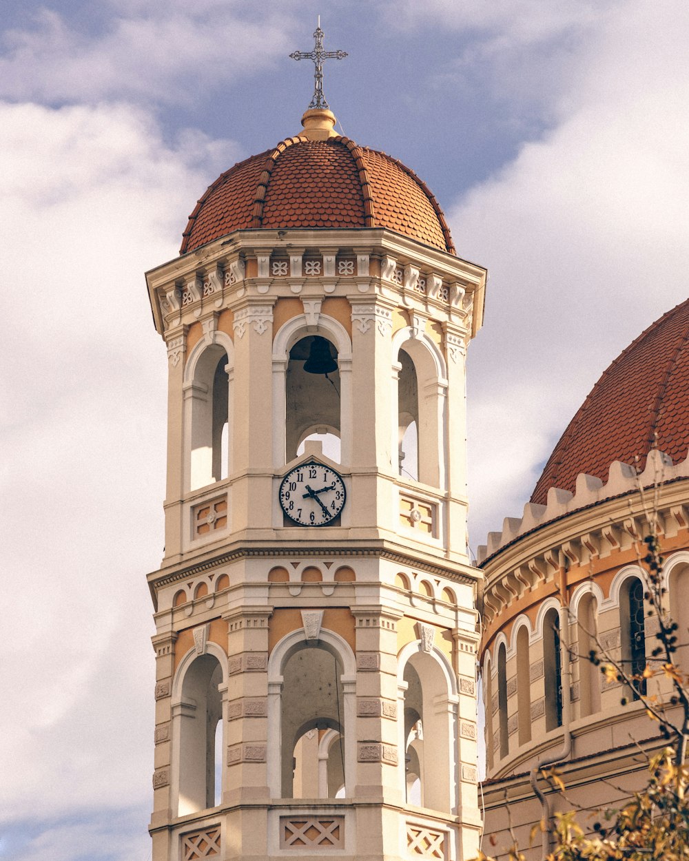 a clock tower with a cross on top of it