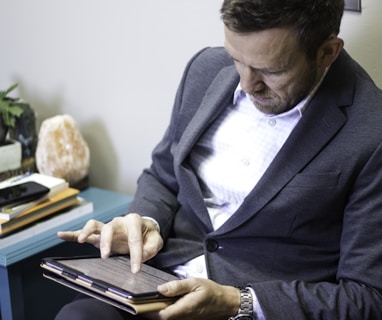 a man in a suit is holding a tablet