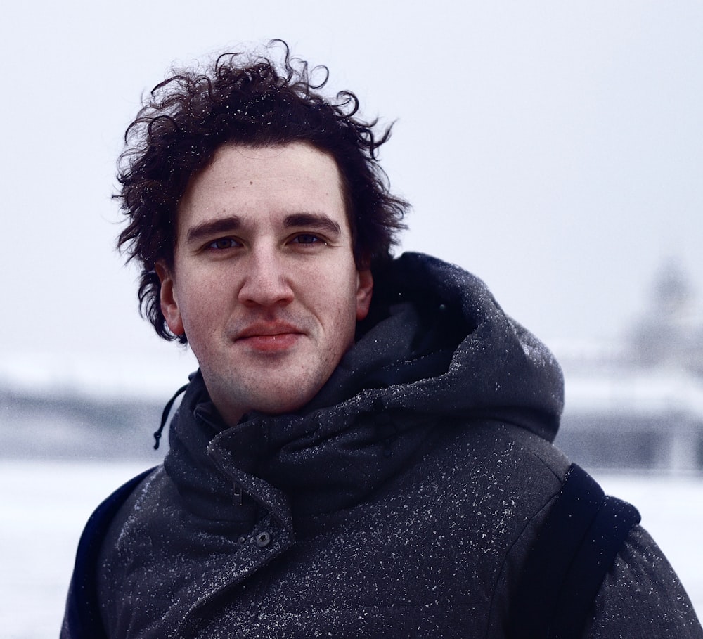 a man with curly hair wearing a black jacket