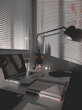 A bright workspace with a laptop and notebook on a desk.