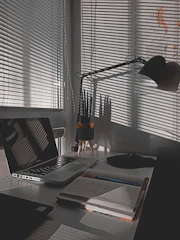 Single room desk space with a lamp and a small plant.
