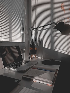 A bright workspace with a laptop and notebook on a desk.