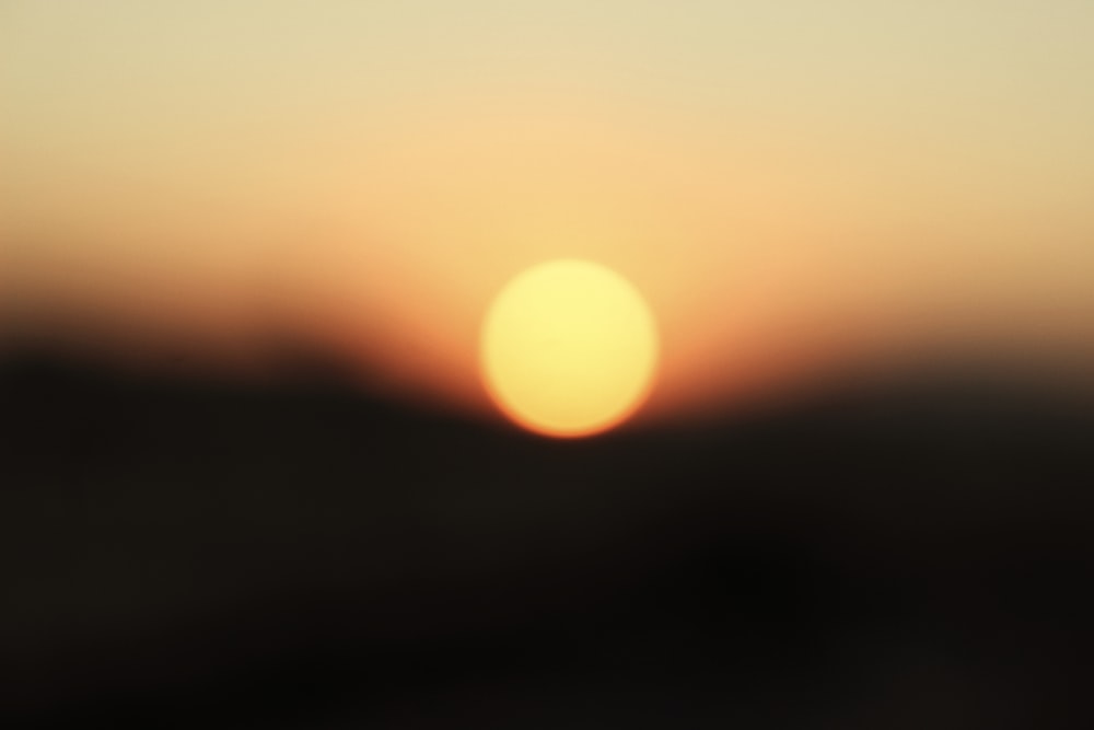 a blurry photo of the sun setting in the sky