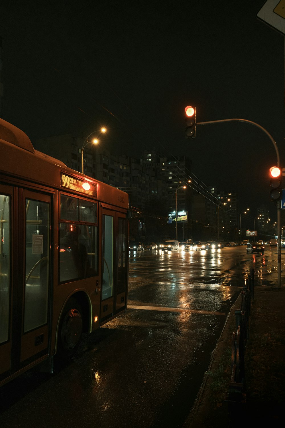 a city bus stopped at a bus stop at night