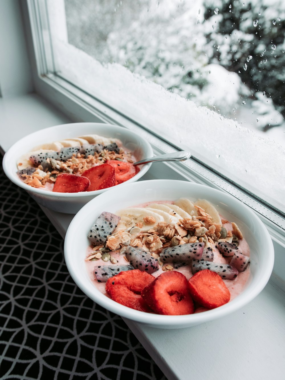 a couple of bowls of food on a window sill