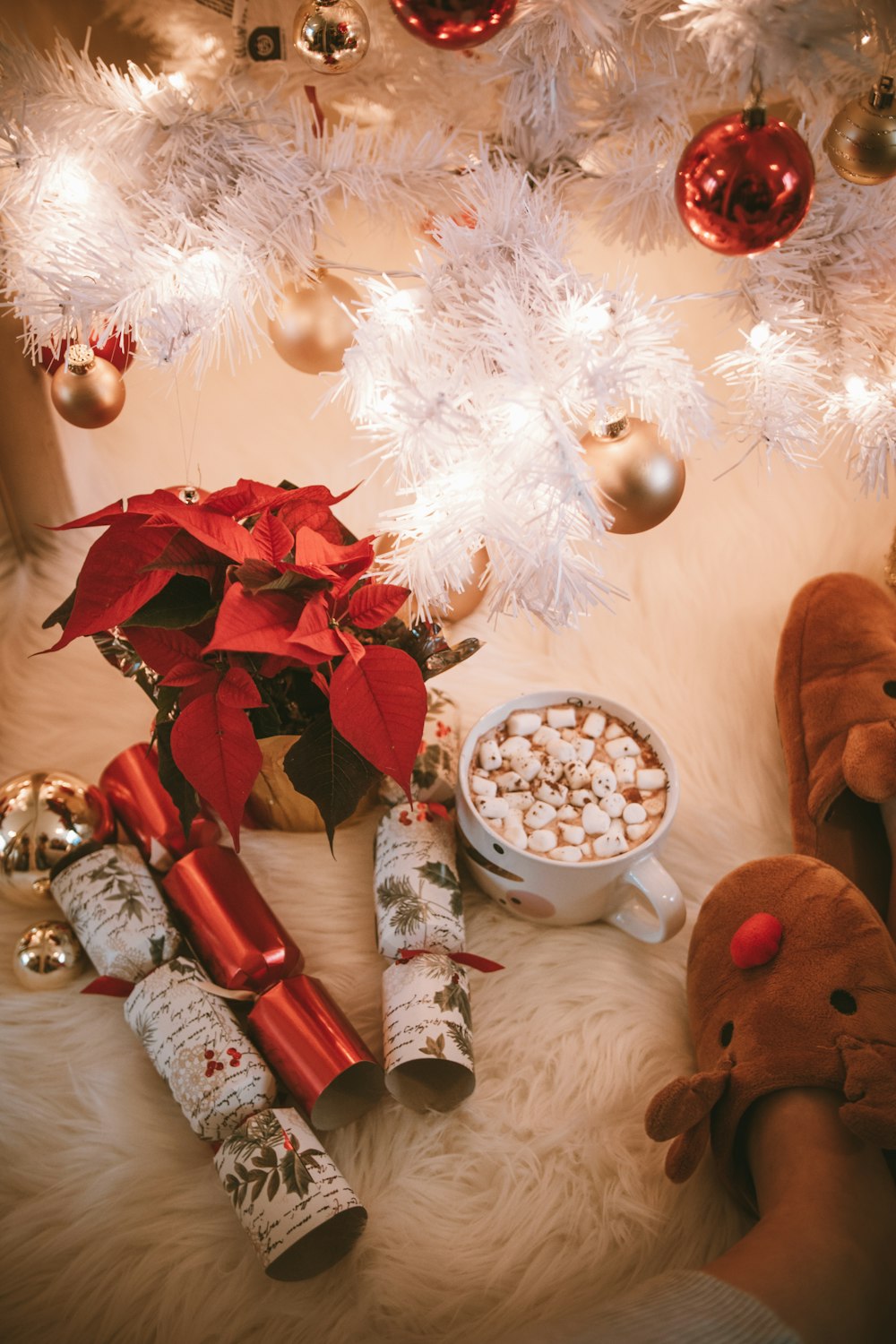 uma árvore de Natal branca com decorações vermelhas e douradas