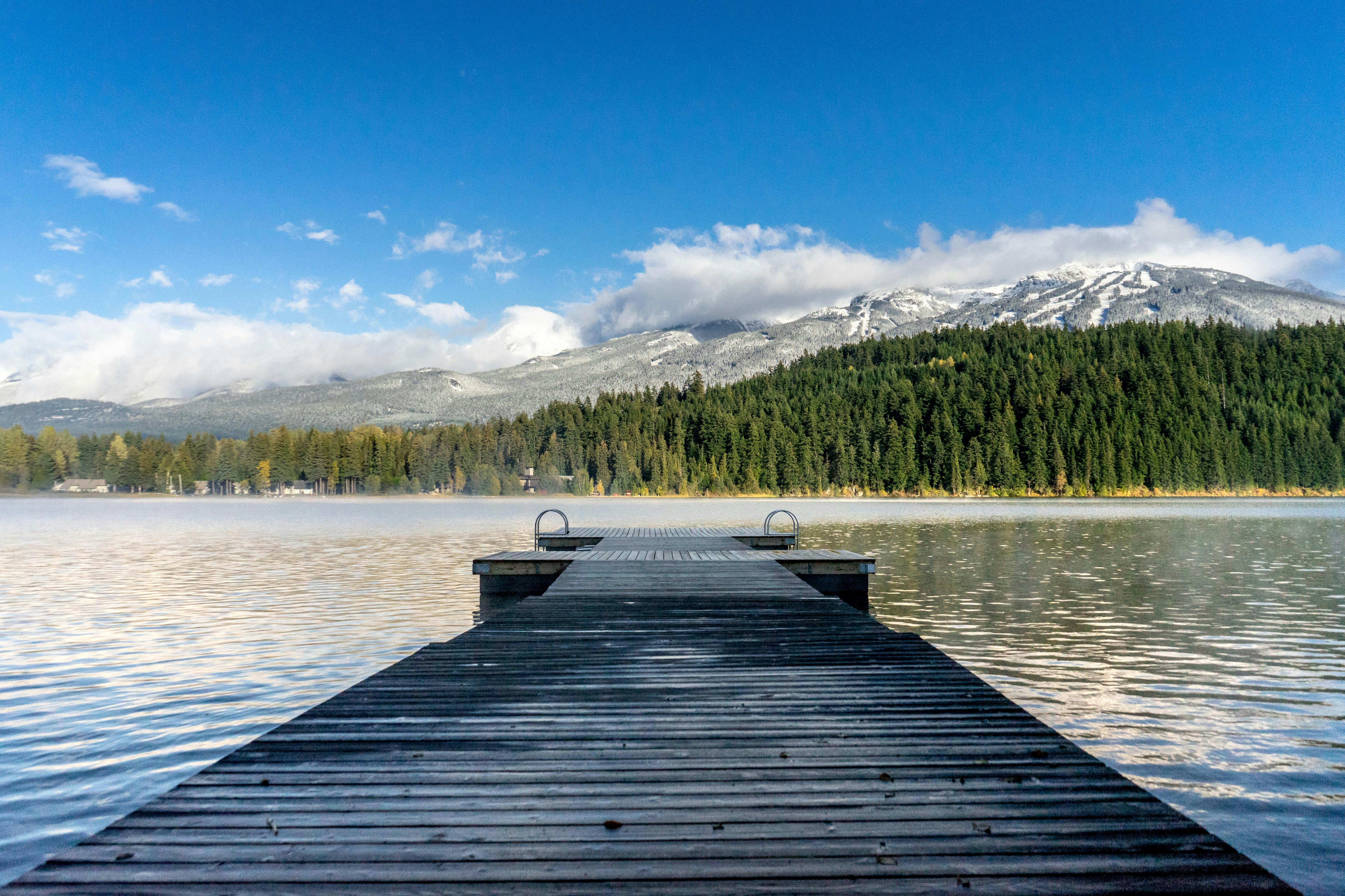 a dock on a lake with mountains in the background
