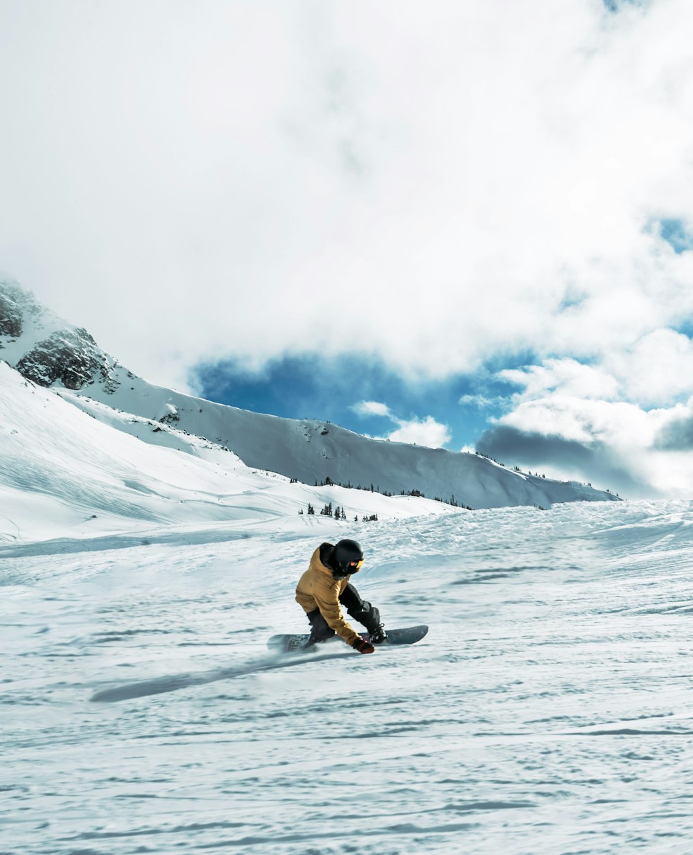 a person riding a snowboard down a snow covered slope