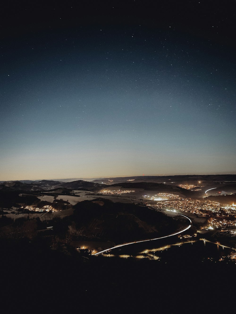 a night view of a city from a hill