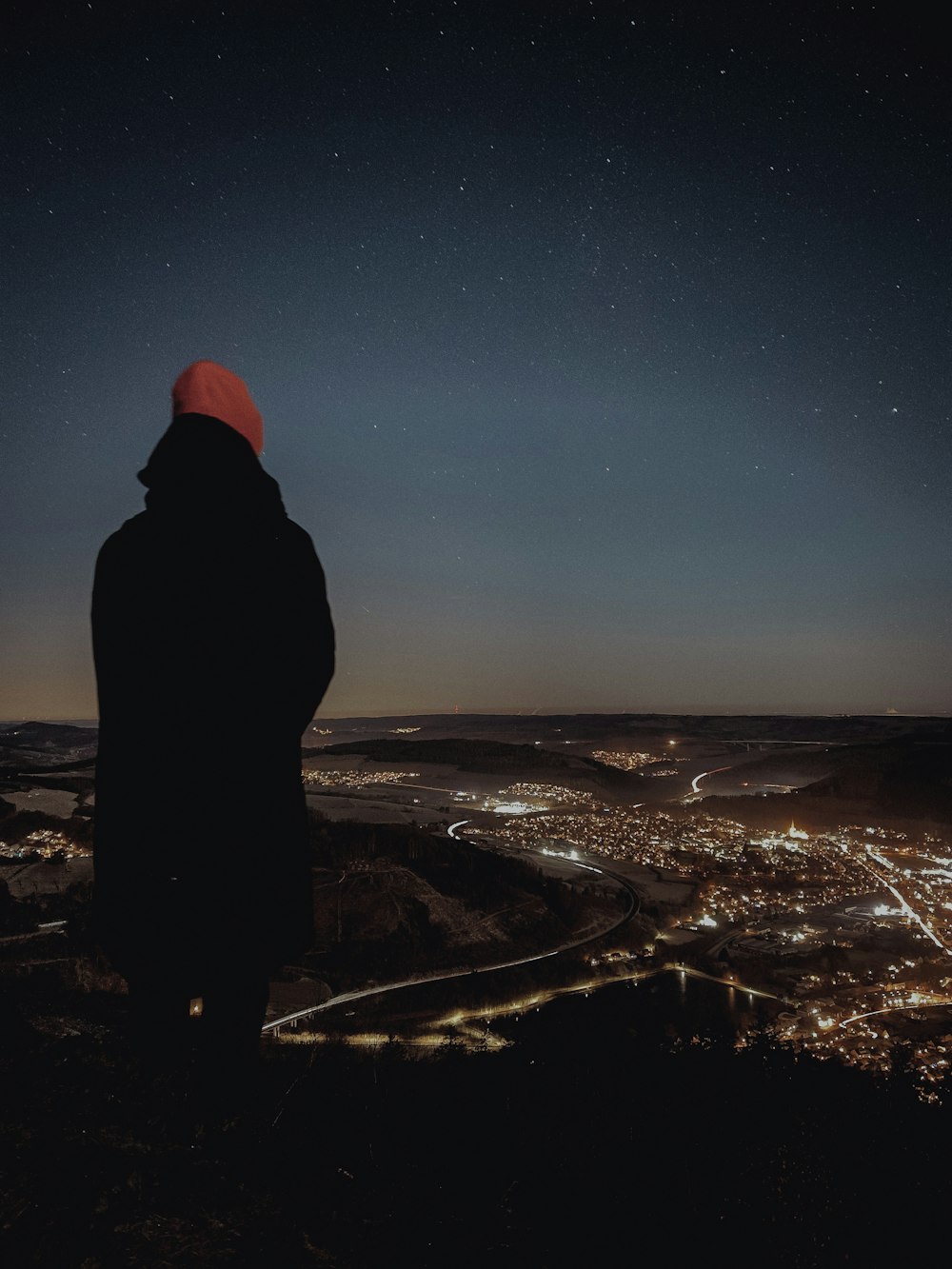 a person standing on top of a hill at night