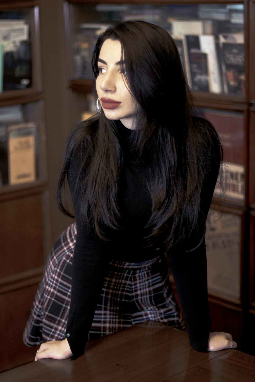 a woman sitting at a table in a library