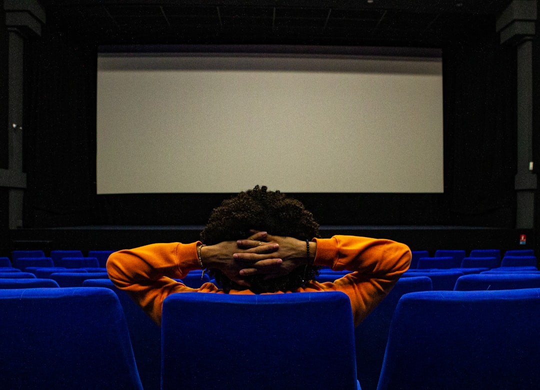 Homme seul devant un écran de cinema. Blue and orange. Cinema, Theatre, film, screen.