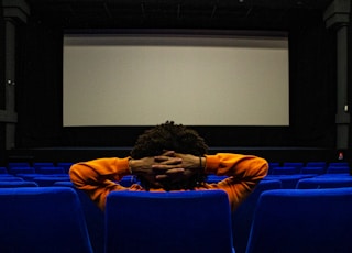 a person sitting in a chair in front of a projection screen