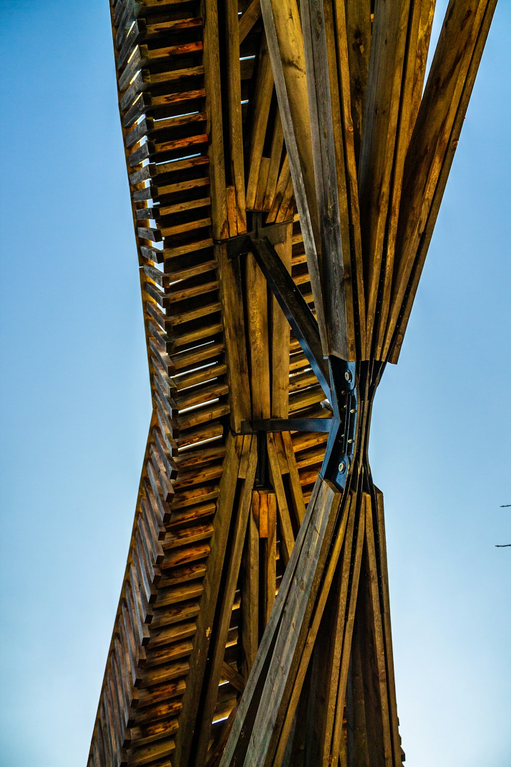 the underside of a wooden structure against a blue sky