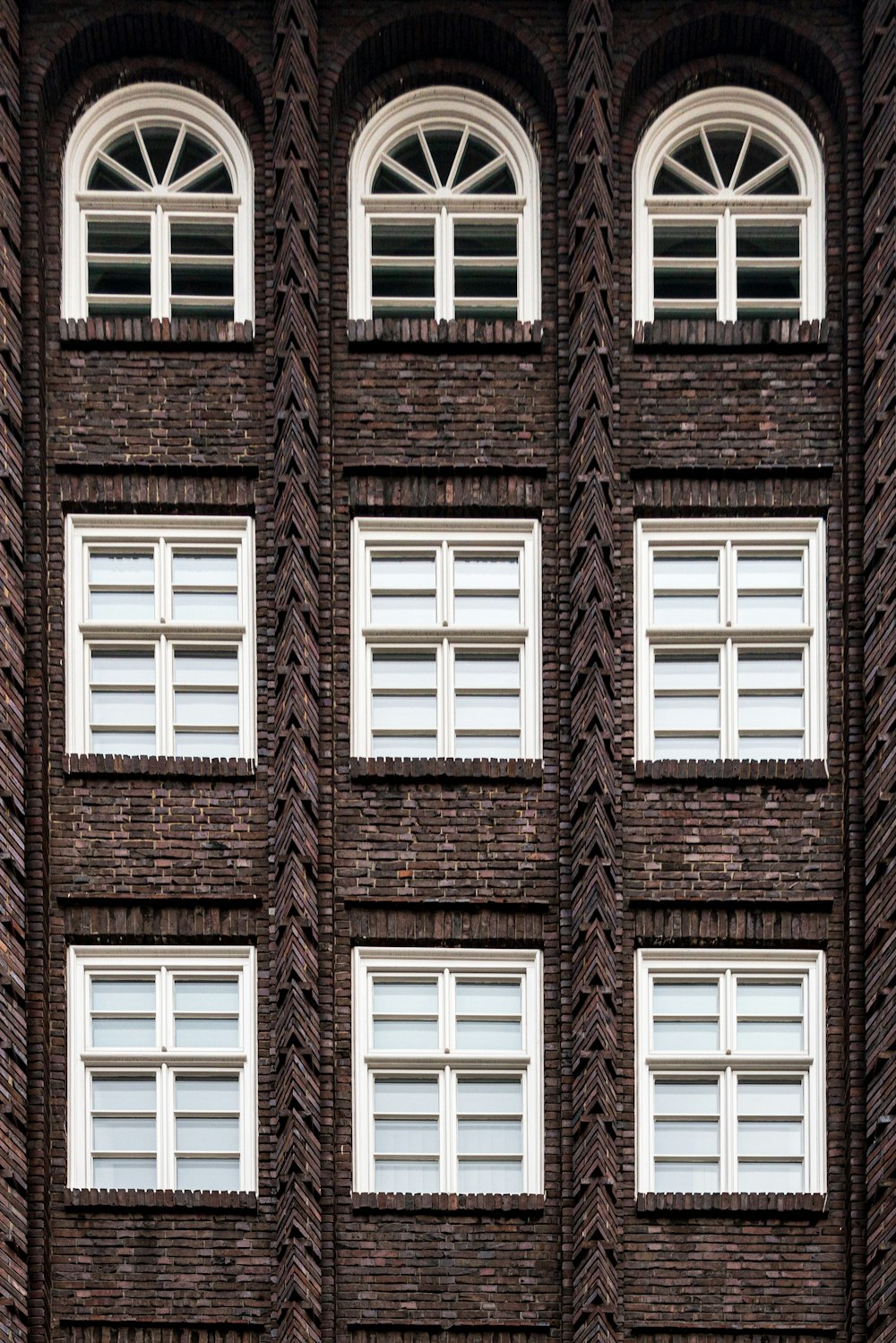 a tall brick building with windows and a clock